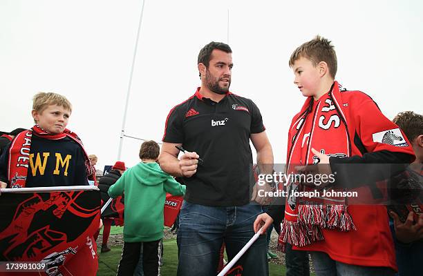 Corey Flynn of the Crusaders sign autographs after a media announcement that BNZ will be naming rights sponsor of the Crusaders on July 19, 2013 in...