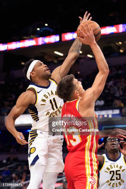 Bruce Brown of the Indiana Pacers blocks the shot of Bogdan Bogdanovic of the Atlanta Hawks during the first half at Gainbridge Fieldhouse on October...