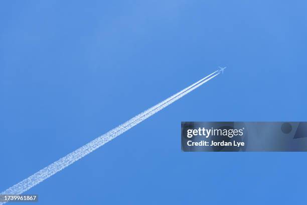long trail of jet plane on blue sky - concorde airplane stock pictures, royalty-free photos & images