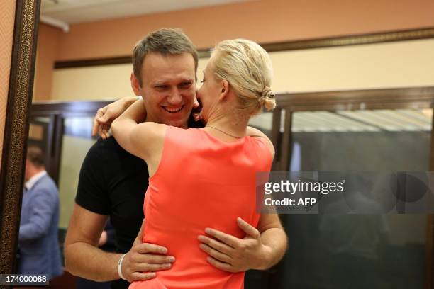 Russia's top opposition leader Alexei Navalny hugs his wife Yulia in the courtroom in Kirov on July 19, 2013. A Russian court on Friday unexpectedly...