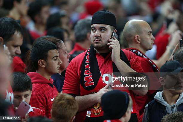 Manchester United fans watch from the stand during a first team training session as part of their pre-season tour of Bangkok, Australia, China, Japan...