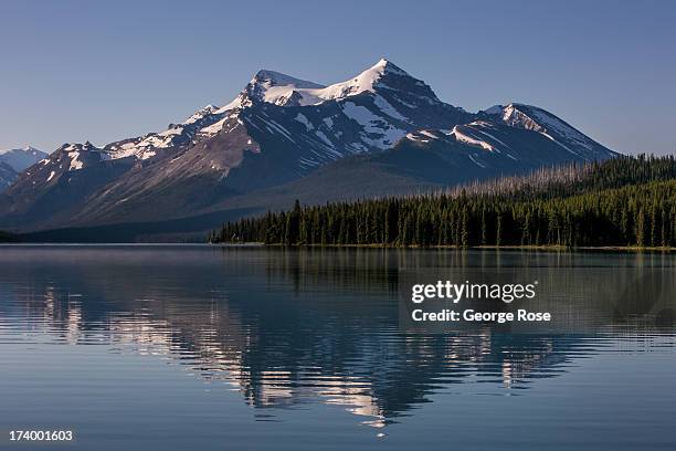 The surrounding snowcapped mountains are reflected in Maligne Lake on June 30, 2013 near Jasper, Alberta, Canada. Jasper is the largest National Park...