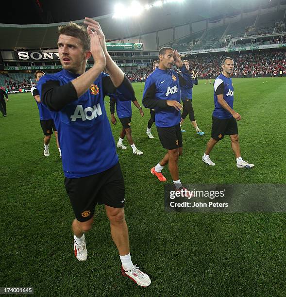 Michael Carrick, Rio Ferdinand and Ryan Giggs of Manchester United applaud the fans after a first team training session as part of their pre-season...