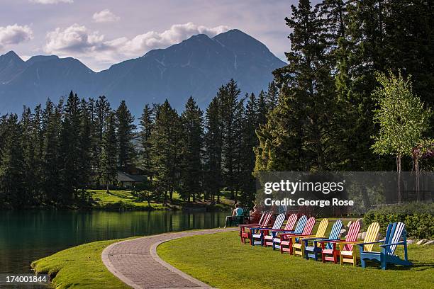 Colorful Adirondack chairs are lined up along Beauvert Lake at the Fairmont Jasper Park Lodge on June 24, 2013 near Jasper, Alberta, Canada. Jasper...