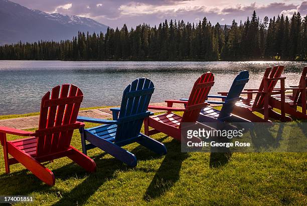 Colorful Adirondack chairs are lined up along Beauvert Lake at the Fairmont Jasper Park Lodge on June 24, 2013 near Jasper, Alberta, Canada. Jasper...