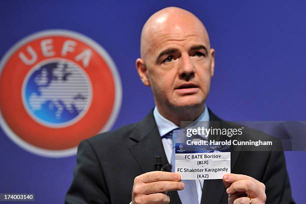 Gianni Infantino, UEFA General Secretary, shows the names FC BATE Borisov /FC Shakhter Karagandy during the UEFA Champions League Q3 qualifying round...