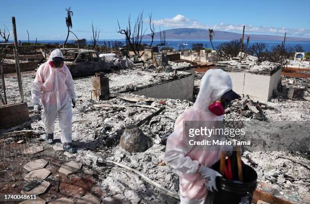 Volunteers from Samaritan's Purse help a daughter search for family items in the rubble of her mother's wildfire destroyed home on October 09, 2023...