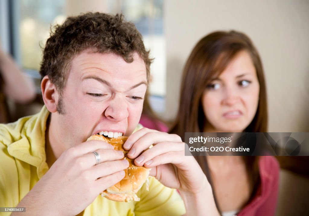 Young Man Eating a Cheeseburger
