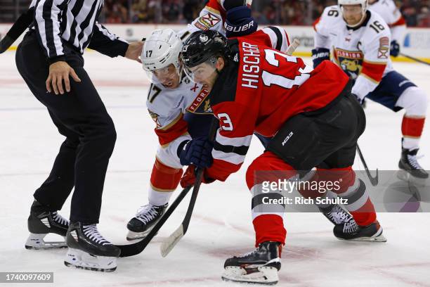 Evan Rodrigues of the Florida Panthers in action against Nico Hischier of the New Jersey Devils during a game at Prudential Center on October 16,...