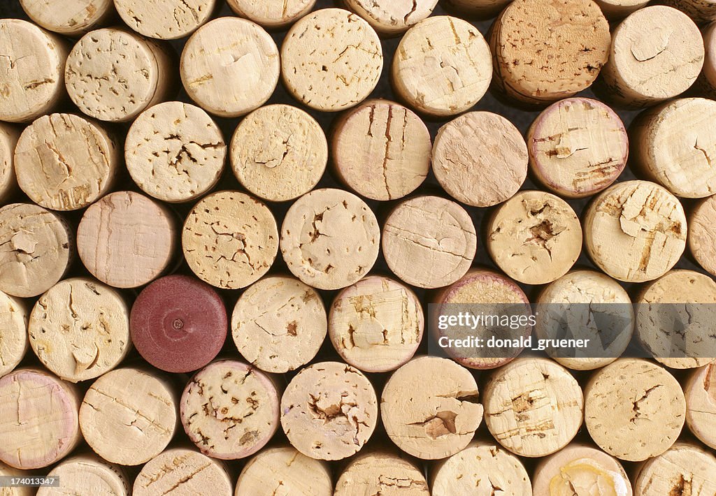 Collection of corks with one red one that doesn't match