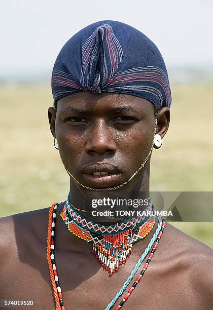 Moran warrior from the Samburu tribe wears a traditional hair-do with his dyed hair locks wrapped in a cloth after cleaning them to protect them from...