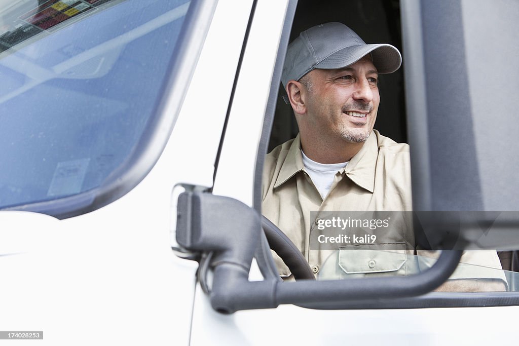 Male truck driver sitting in semi cab