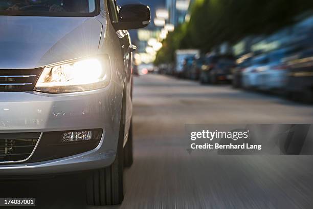 car driving on urban street, low angle view - car front view no people stock-fotos und bilder