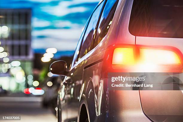 car standing on urban street, rear view - tail light stock pictures, royalty-free photos & images