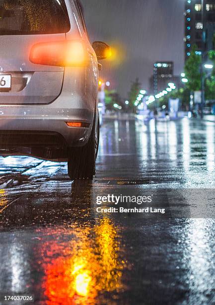 car standing on street in the rain, rear view - brake lights foto e immagini stock