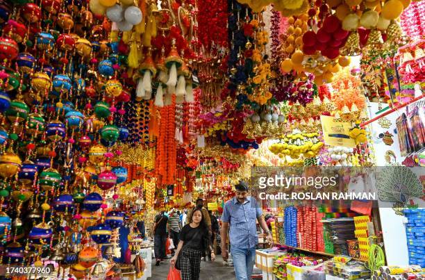 Shoppers walk under decorative ornaments displayed for sale in a market at Little India district in Singapore on October 23 ahead of Hindu festive...