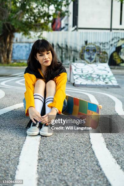 skater chic: confident asian girl rocking the skatepark in style - modern rock stock pictures, royalty-free photos & images