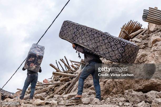 Récupération de matelas dans les décombres dans le village de Imi N'Tala le 12 septembre 2023.