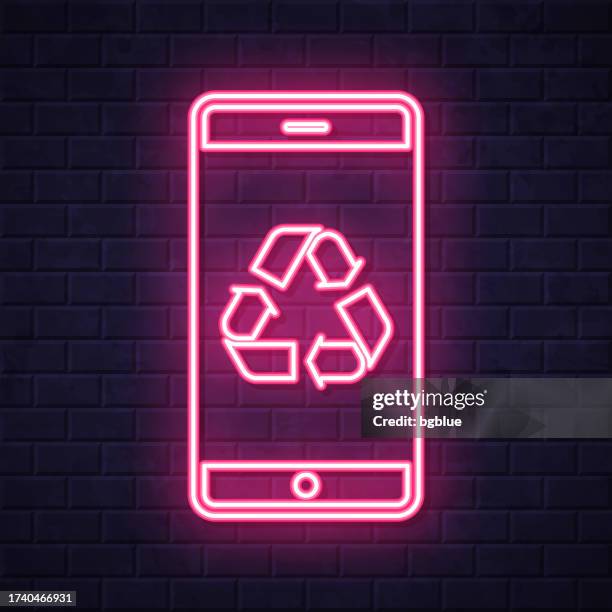 smartphone with recycle symbol. glowing neon icon on brick wall background - touch screen wall stock illustrations