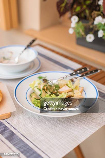 bowl of chicken salad with chickpeas, cucumber and lettuce on a terrace - place mat stock pictures, royalty-free photos & images
