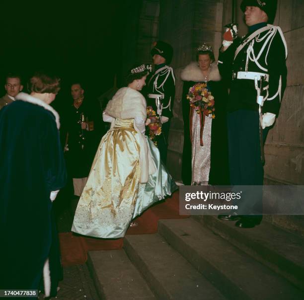 Queen Elizabeth II of Great Britain and Queen Juliana of the Netherlands carry bouquets as they arrive at the Royal Concertgebouw concert hall in...