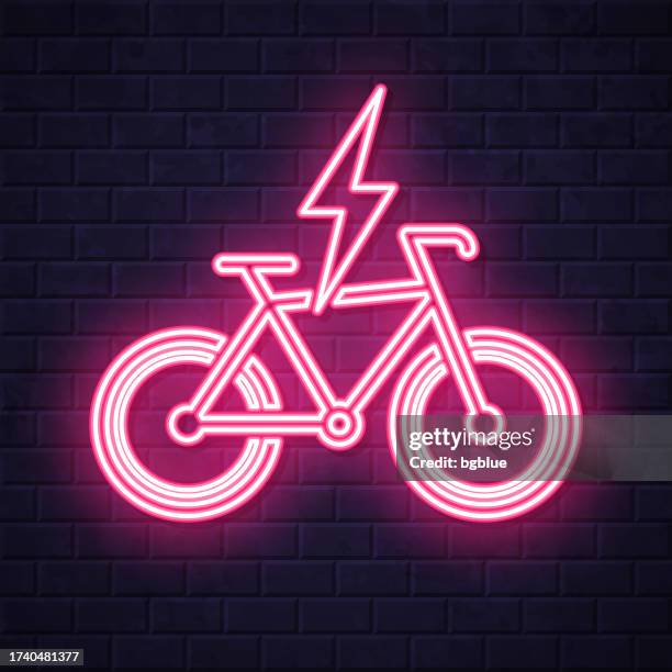 electric bike in charge. glowing neon icon on brick wall background - neon bikes stock illustrations