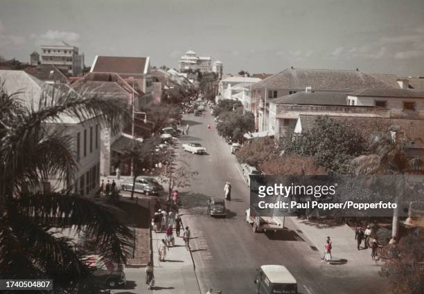 Pedestrians pass cars and trucks on Bay Street in Nassau, The Bahamas, circa 1950. Visible in background is the British Colonial Hotel.
