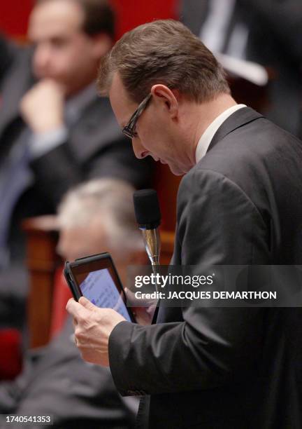 French UMP right-wing ruling party for the Haute-Savoie region Lionel Tardy uses his tablet as he delivers a speech during a debate on a bill, which...