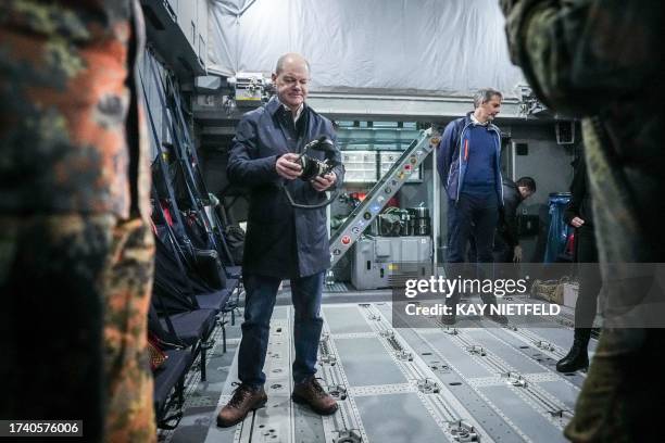 German Chancellor Olaf Scholz stands in an Airbus A400M of the German Air Force on October 23, 2023 in Berlin, before taking off bound to the...