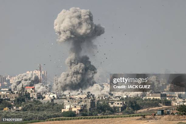 Graphic content / TOPSHOT - A picture taken from the southern Israeli city of Sderot on October 23 shows smoke and debris ascending over the northern...