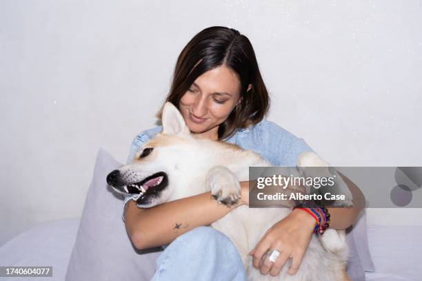 a woman smiling while hugging her dog - flash stock pictures, royalty-free photos & images