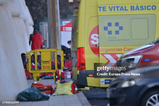 An ambulance next to migrants who have arrived this morning in a patera to the island of El Hierro, on 17 October, 2023 in El Hierro, Canary Islands,...