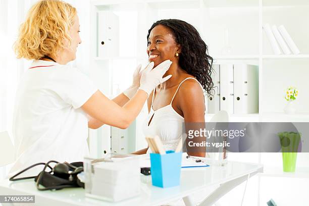 mid age african woman visit doctor. - thyroid exam stock pictures, royalty-free photos & images