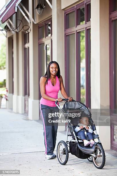 afro-americana mãe empurrando carrinho de criança no passeio - baby stroller imagens e fotografias de stock