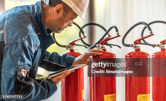A Professional Safety Inspector Inspects Fire Extinguishers High-Res ...