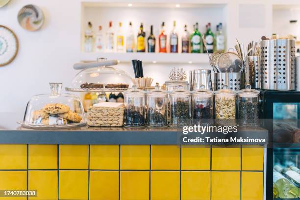 different herbal tea in transparent jars on a yellow bar counter in a café. banks line up. - red salvia stock pictures, royalty-free photos & images