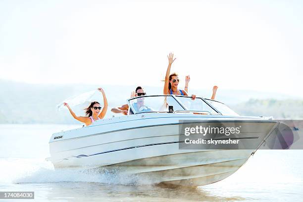 cheerful young people riding in a speedboat. - speedboat stock pictures, royalty-free photos & images