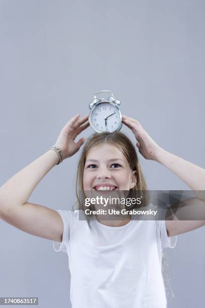 In this photo illustration A girl with an oldschool clock on October 04, 2023 in Bonn, Germany.