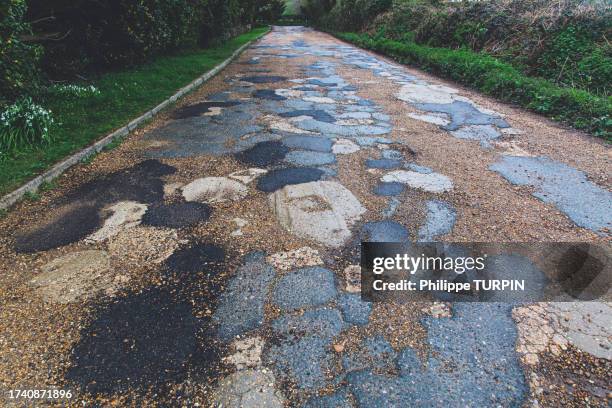 . english road with potholes and bitumen repair - tar stock pictures, royalty-free photos & images