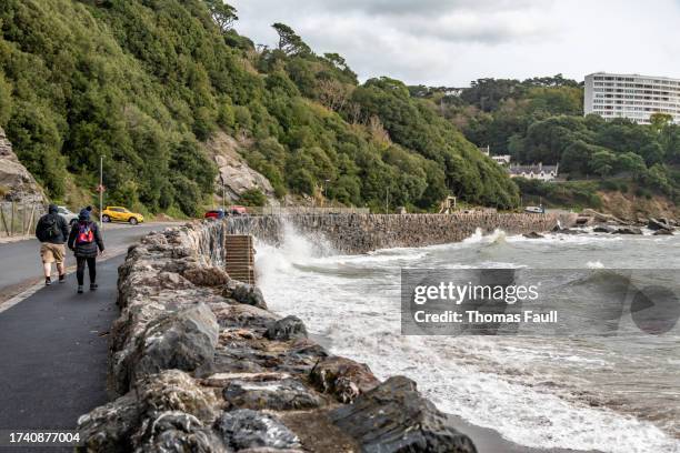 walking in stormy weather at meadfoot beach - seawall stock pictures, royalty-free photos & images