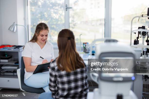 l'infermiera prende i dati da un paziente adolescente - miopia foto e immagini stock