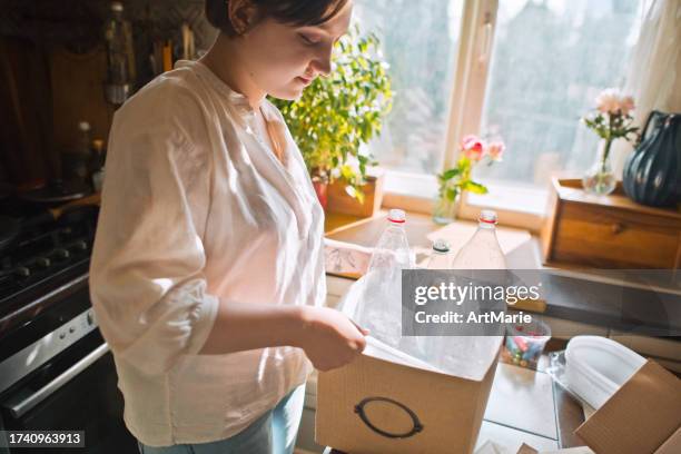 young woman sorting out waste at home . sustainable lifestyle and garbage recycling concept. - reduce stock pictures, royalty-free photos & images