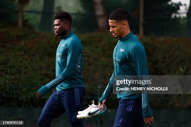 Arsenal's Ghanaian midfielder Thomas Partey and Arsenal's French defender William Saliba arrive to attend a team training session at Arsenal's...