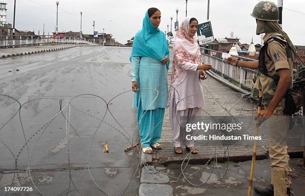 Paramilitary soldier checking identity card of women during second day of curfew on July 20, 2013 in Srinagar, India. Curfew remained in force for...