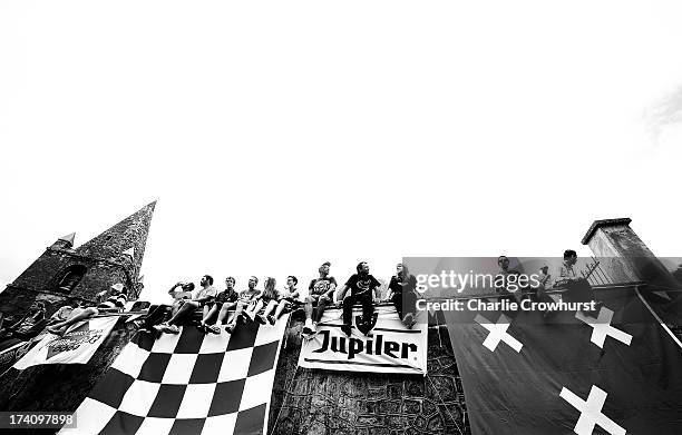 Spectators sit on the church wall at Dutch corner during stage eighteen of the 2013 Tour de France, a 172.5KM road stage from Gap to l'Alpe d'Huez,...