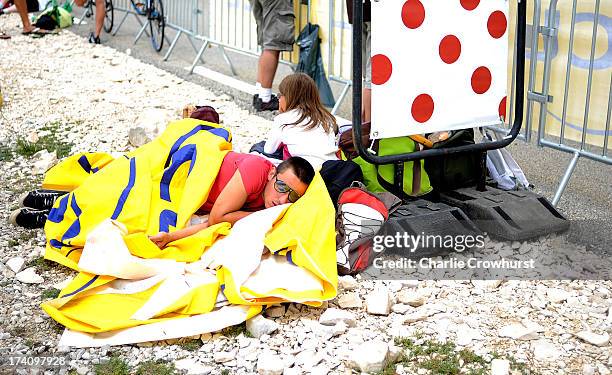 Spectator sleeps usuing the LCL banner as cover at the top of Mont Ventoux during stage fifteen of the 2013 Tour de France, a 242.5KM road stage from...