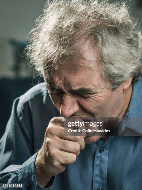 senior man coughing into hand - yawning is contagious stock pictures, royalty-free photos & images