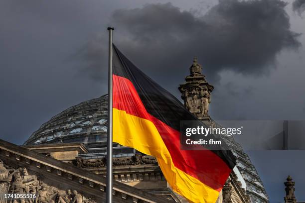 german flag with dome of the reichstag building (deutscher bundestag/ german parliament building) - german flag wallpaper stock-fotos und bilder