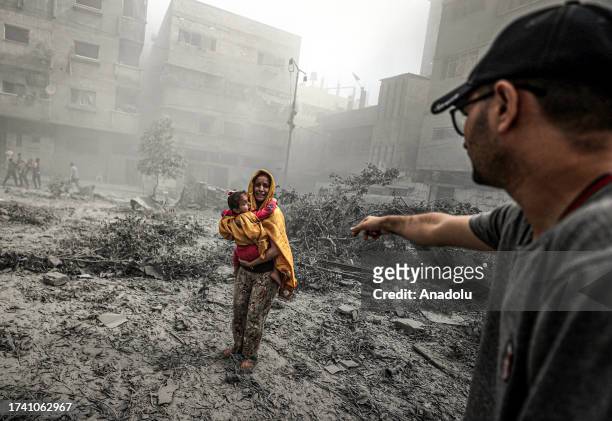 Woman holding a girl reacts after Israeli airstrikes hit Ridwan neighborhood of Gaza City, Gaza on October 23, 2023.
