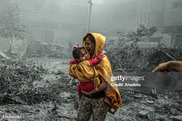 Woman holding a girl reacts after Israeli airstrikes hit Ridwan neighborhood of Gaza City, Gaza on October 23, 2023.